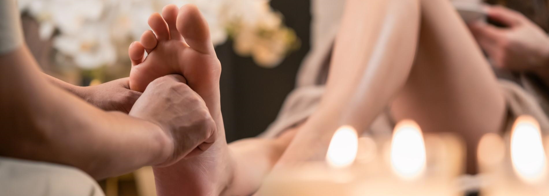 Woman having reflexology foot massage in wellness spa